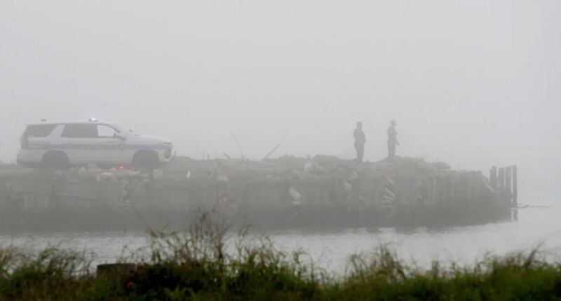 Galveston Police officers watch the water on Galveston Bay west of the Galveston causeway, Monday, Dec. 22, 2025, near Galveston, Texas, as emergency personnel search for a small airplane that went down in the bay in heavy fog. (Jennifer Reynolds/The Galveston County Daily News via AP)