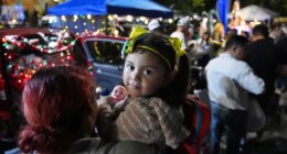 A little girl holds a doll, one of many gifts distributed at dozens of open-air altars to the Virgin Mary, as Nicaraguan parishioners of St. John Bosco Catholic Church celebrate the Dec. 8 feast of the Immaculate Conception, Sunday, Dec. 7, 2025, in Miami. (AP Photo/Rebecca Blackwell)