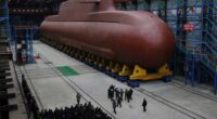 In this undated photo provided Thursday, Dec. 25, 2025, by the North Korean government, its leader Kim Jong Un inspects a nuclear-powered submarine under construction at an undisclosed location.