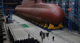 In this undated photo provided Thursday, Dec. 25, 2025, by the North Korean government, its leader Kim Jong Un inspects a nuclear-powered submarine under construction at an undisclosed location.