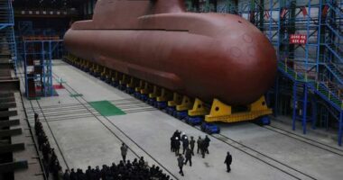 In this undated photo provided Thursday, Dec. 25, 2025, by the North Korean government, its leader Kim Jong Un inspects a nuclear-powered submarine under construction at an undisclosed location.
