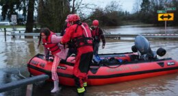 Maery Schine, 11, is helped out of a rescue boat by rescue workers with Chehalis Fire after evacuating with her father Patric, second from left, following flooding after heavy rains in the region Tuesday, Dec. 9, 2025, in Chehalis, Wash. (AP Photo/Lindsey Wasson)