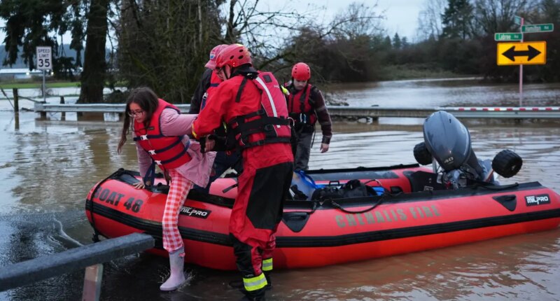 Maery Schine, 11, is helped out of a rescue boat by rescue workers with Chehalis Fire after evacuating with her father Patric, second from left, following flooding after heavy rains in the region Tuesday, Dec. 9, 2025, in Chehalis, Wash. (AP Photo/Lindsey Wasson)