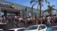 Vision shows hundreds of young beachgoers storming the Woolworths store.