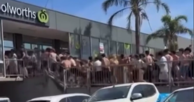 Vision shows hundreds of young beachgoers storming the Woolworths store.
