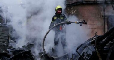 A rescue worker puts out a fire of a house destroyed after a Russian strike on Kyiv, Ukraine, on Saturday, Dec. 27, 2025. (AP Photo/Evgeniy Maloletka)