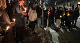 A crowd of people holding candles gather outside the home of Massachusetts Institute of Technology professor Nuno F.G. Loureiro in Brookline, Mass., Tuesday, Dec. 16, 2025. (AP Photo/Leah Willingham)