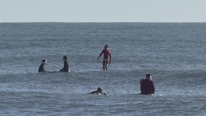 Surfing Santas ride Christmas Eve waves in Cocoa Beach, raising money for local charities
