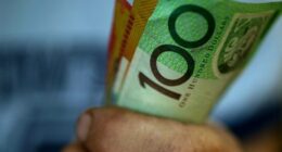 Someone clutching a handful of $50 and $100 notes.