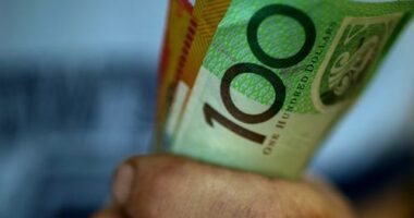 Someone clutching a handful of $50 and $100 notes.