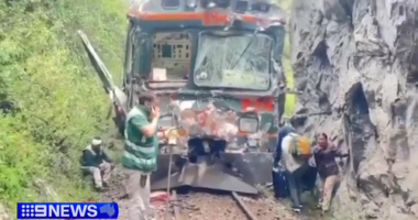 Videos on local media showed train cars with broken windows and dented sides stuck along a rail line hemmed in between a lush forest and a massive rock.