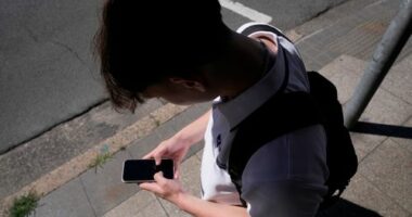 A teenage boy uses his phone for social media in Sydney, Nov. 8, 2024.