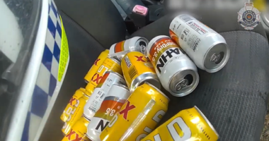 The officer found more than a dozen empty cans of beer under the driver's seat of the red Suzuki.