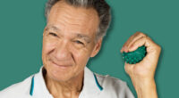 Mature man holding and squeezing massage therapy spike balls