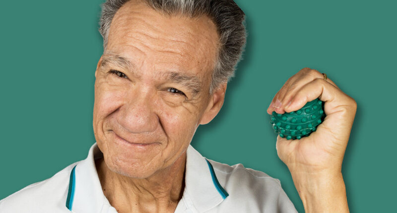 Mature man holding and squeezing massage therapy spike balls