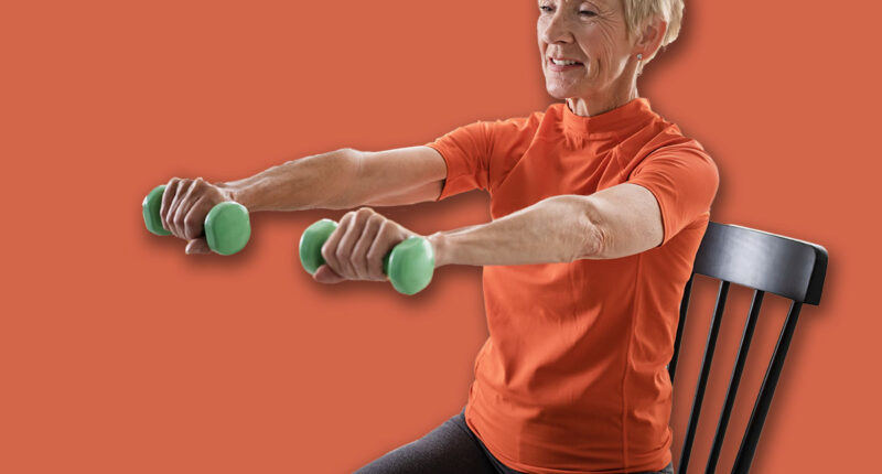 Smiling beautiful senior woman health instructor doing chair exercises with dumbbells