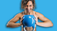 Woman powerfully holding kettlebell, showing strength during workout
