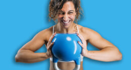 Woman powerfully holding kettlebell, showing strength during workout