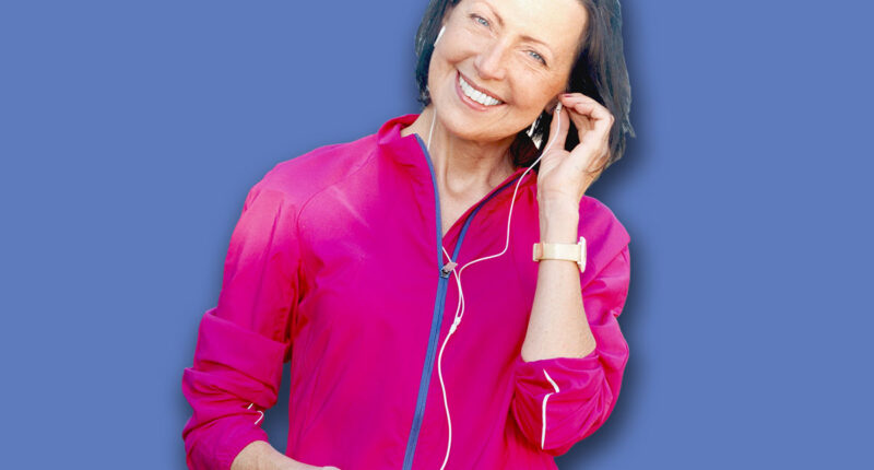 Mature woman listen music before or after jog in the park. Attractive looking mature woman keeping fit and healthy