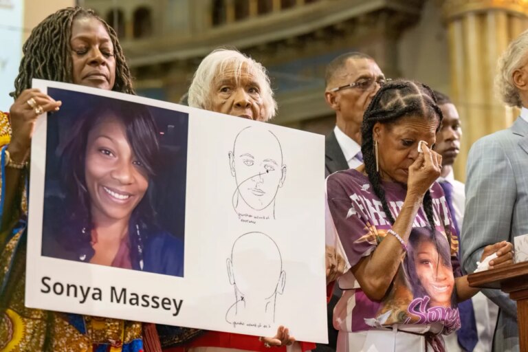 FILE - Donna Massey, center right, wipes tears from her face as she listens to Rev. Al Sharpton, right, speak during a press conference over the shooting death of her daughter, Sonya, who was killed by Illinois sheriff