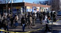 Federal agents stand near the site of a shooting Saturday, Jan. 24, 2026, in Minneapolis. (AP Photo/Abbie Parr)
