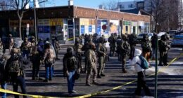 Federal agents stand near the site of a shooting Saturday, Jan. 24, 2026, in Minneapolis. (AP Photo/Abbie Parr)
