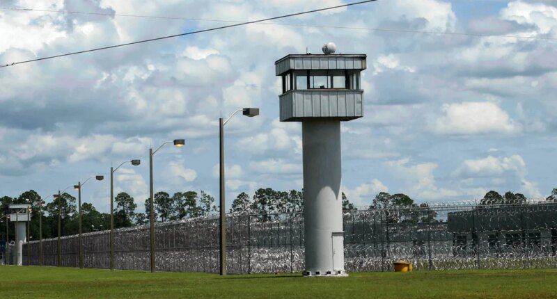 FILE - Fence and towers at the Baker Correctional Institution, Sanderson, Fla., Thursday, Aug. 14, 2025. (AP Photo/Gary McCullough, File)