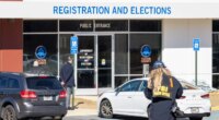 An FBI press office person approaches the Fulton County Election Hub and Operation Center, Wednesday, Jan. 28, 2026, in Union City, Ga. (Arvin Temka/Atlanta Journal-Constitution via AP)