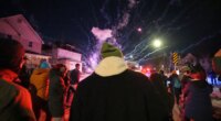 People react after a firework was set off near the scene of a reported shooting Wednesday, Jan. 14, 2026, in Minneapolis. (AP Photo/Abbie Parr)