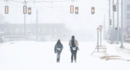 Jimmy Jordan, left, and Cordarol Dale walk through snow in Memphis, Tenn., Saturday, Jan. 24, 2026. (Mark Weber/Daily Memphian via AP)