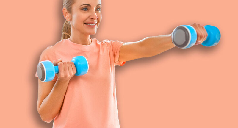 Sport, fitness and healthy lifestyle concept. Mature woman doing exercises with dumbbells at home. How to stay healthy in quarantine.