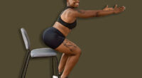 Young african american couple training using chair at sport center.