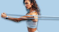 Strong woman workout with resistance band. Side view of young female using stretch bands.
