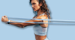 Strong woman workout with resistance band. Side view of young female using stretch bands.