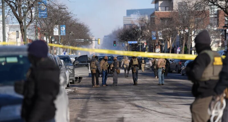 Federal agents stand near the site of a shooting Saturday, Jan. 24, 2026, in Minneapolis. (AP Photo/Abbie Parr)