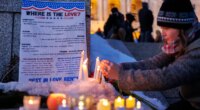 Candles burn around a poem written by Renee Good during a vigil honoring her on Friday, Jan. 9, 2026, in St. Paul, Minn., outside the Minnesota State Capitol. (Kerem Yücel/Minnesota Public Radio via AP)