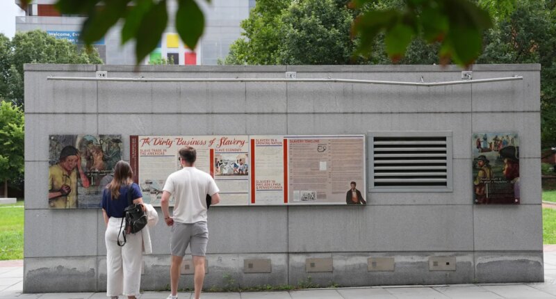 FILE - People look an informational panel at President