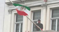 Protester scales Iranian Embassy in London, tears down regime flag, hoists pre-revolution symbol