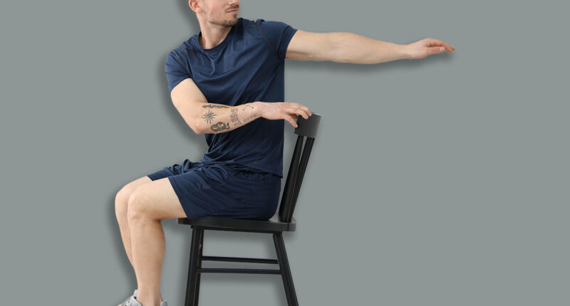 Handsome man exercising with chair at home