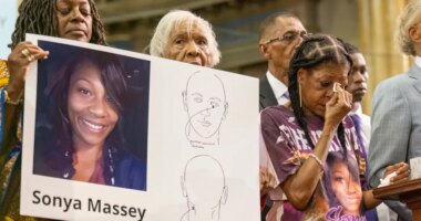 FILE - Donna Massey, center right, wipes tears from her face as she listens to Rev. Al Sharpton, right, speak during a press conference over the shooting death of her daughter, Sonya, who was killed by Illinois sheriff
