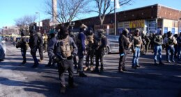 Federal agents stand near the site of a shooting Saturday, Jan. 24, 2026, in Minneapolis. (AP Photo/Abbie Parr)