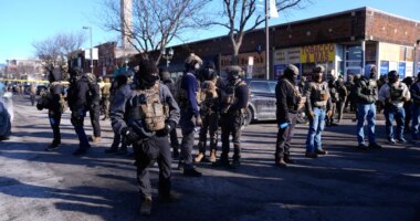 Federal agents stand near the site of a shooting Saturday, Jan. 24, 2026, in Minneapolis. (AP Photo/Abbie Parr)