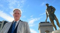 FILE - Developer Rodney Mims Cook Jr. stands next to the statue of Chief Tomochichi he commissioned for Atlanta