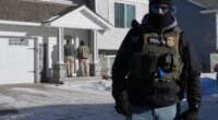 Federal agents knock on a door of a residence on Wednesday, Jan. 28, 2026, in Blaine, Minn. (AP Photo/Adam Gray)