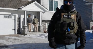 Federal agents knock on a door of a residence on Wednesday, Jan. 28, 2026, in Blaine, Minn. (AP Photo/Adam Gray)