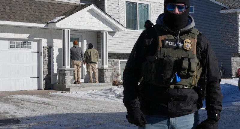 Federal agents knock on a door of a residence on Wednesday, Jan. 28, 2026, in Blaine, Minn. (AP Photo/Adam Gray)