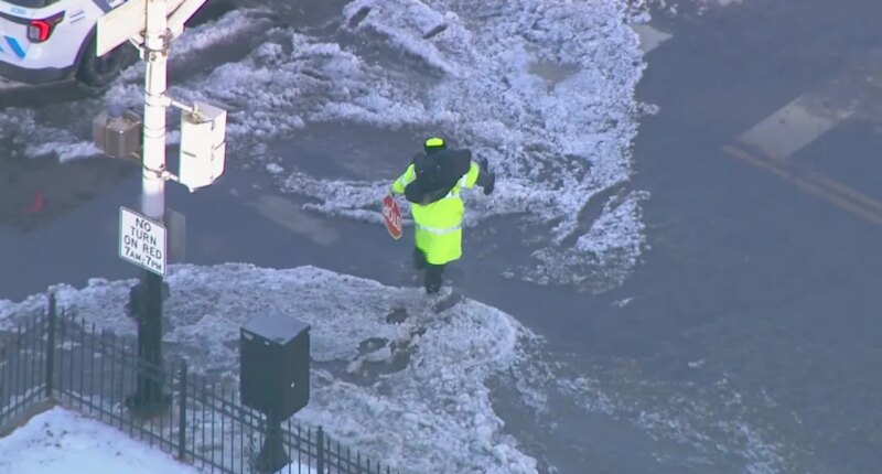 WATCH: Crossing guard carries child across flooded Chicago street