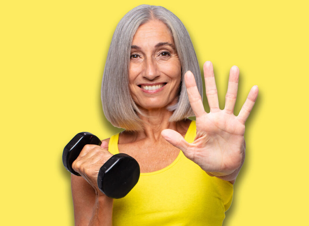 middle age woman smiling and looking friendly, showing number five or fifth with hand forward, counting down. fitness concept