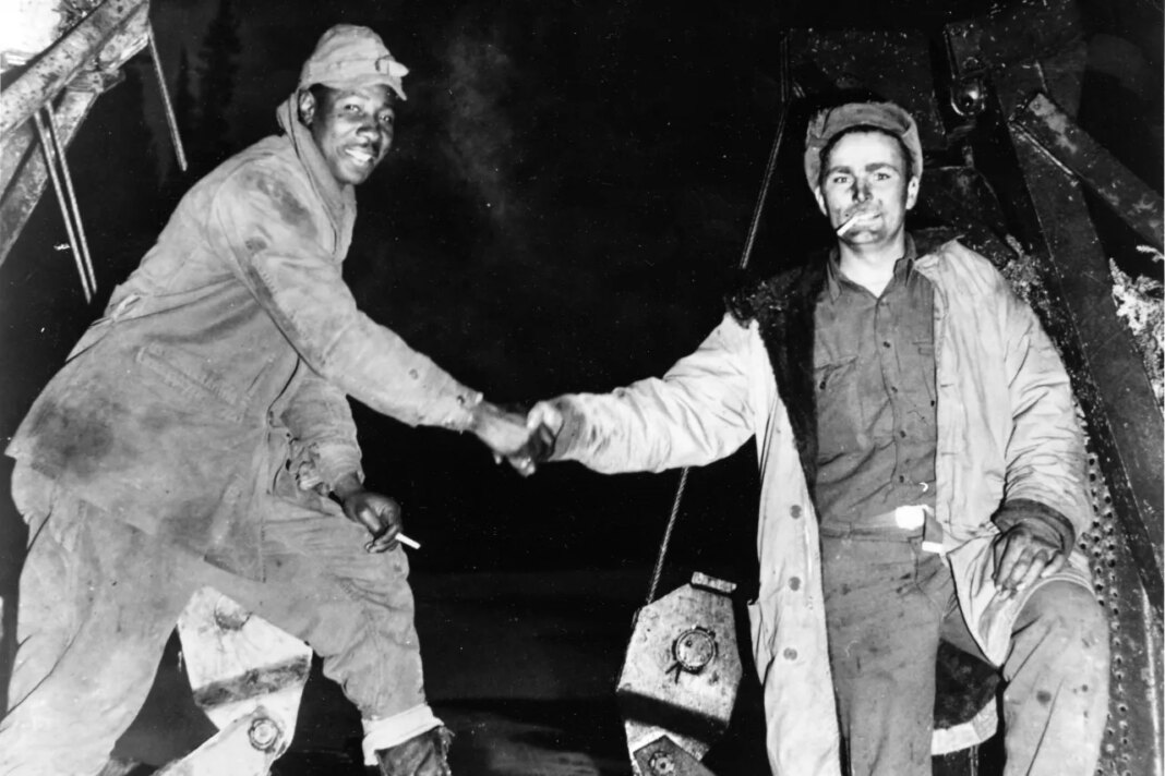 FILE - This Oct. 25, 1942, photo provided by the U.S. Army Corps of Engineers Office of History, shows Corporal Refines Slims, Jr., left, and Private Alfred Jalufka shaking hands at the, 