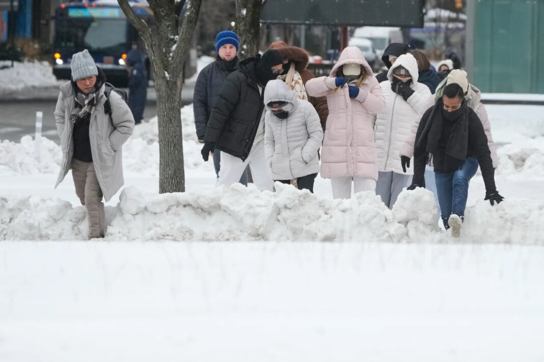 FILE - Pedestrians climb over snow banks to try and cross the streets in New York, Monday, Jan. 26, 2026. (AP Photo/Seth Wenig, File)